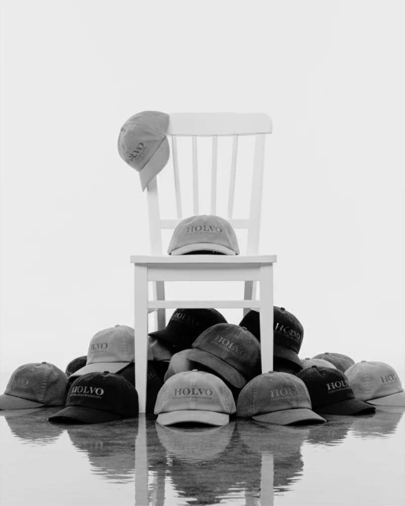 Holvo caps piled around and on a white wooden chair, reflected in water